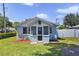 Inviting light-blue home featuring a screened porch and tidy front lawn with red mulch at 233 E Church Ave, Longwood, FL 32750