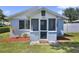 Charming home with a cozy screened porch, front yard landscaping, and white trimmed windows at 233 E Church Ave, Longwood, FL 32750