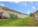 View of a fenced backyard with green grass and garden beds along the back of the house at 2518 Hayden Valley St, Apopka, FL 32703