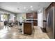 Spacious kitchen with an island, stainless steel refrigerator, and brown cabinets with an adjacent dining area at 2518 Hayden Valley St, Apopka, FL 32703