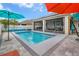 Backyard pool with a screen-in patio, solar panels, and colorful umbrellas at 2518 Hayden Valley St, Apopka, FL 32703