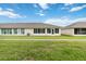 Rear view of a single-story home with enclosed sunroom and manicured lawn at 2640 Shelby Ruth Pl, St Cloud, FL 34769