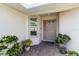 Covered front porch featuring a neutral door, window, and potted plants adding a touch of nature at 2640 Shelby Ruth Pl, St Cloud, FL 34769