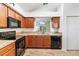 Eat-in kitchen with sleek black appliances and warm wood cabinets at 2640 Shelby Ruth Pl, St Cloud, FL 34769