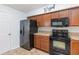 Eat-in kitchen with sleek black appliances and warm wood cabinets at 2640 Shelby Ruth Pl, St Cloud, FL 34769