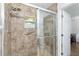 Tiled shower with glass door, showerhead, and a grab bar for accessibility at 2640 Shelby Ruth Pl, St Cloud, FL 34769