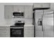 Kitchen with stainless steel appliances and grey cabinets at 2643 Alamosa Pl, Lake Mary, FL 32746