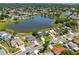 Community aerial showcasing homes surrounding a tranquil lake with lush greenery at 2681 Debany Rd, Kissimmee, FL 34744