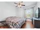 Cozy bedroom with a ceiling fan, wood floors, and a window with curtains at 2681 Debany Rd, Kissimmee, FL 34744