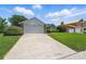 Driveway and exterior of home with well-maintained landscaping and mature trees in the front yard at 2681 Debany Rd, Kissimmee, FL 34744
