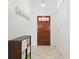 Bright entryway featuring tile flooring, a wooden door with glass panels, and a decorative storage unit at 2681 Debany Rd, Kissimmee, FL 34744