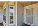Exterior view of front door with security screen and nearby window at 2681 Debany Rd, Kissimmee, FL 34744