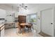 Charming kitchen with a cozy breakfast nook, featuring a wooden dining set and ample natural light from large windows at 2681 Debany Rd, Kissimmee, FL 34744