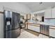 Contemporary kitchen featuring stainless steel appliances, white cabinets, and an open view to the living area at 2681 Debany Rd, Kissimmee, FL 34744