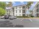 Condominium building featuring balconies, lush greenery, and designated parking area at 2717 Maitland Crossing # 207, Orlando, FL 32810