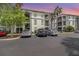 Condominium building exterior showcasing balconies, lush landscaping, and ample parking at 2717 Maitland Crossing # 207, Orlando, FL 32810