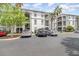 Condominium building exterior showcasing balconies, lush landscaping, and ample parking at 2717 Maitland Crossing # 207, Orlando, FL 32810