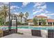Community pool and clubhouse with palm trees and lounge chairs on a sunny day at 2717 Maitland Crossing # 207, Orlando, FL 32810