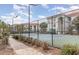 Community tennis court surrounded by fencing, landscaping, and residential buildings at 2717 Maitland Crossing # 207, Orlando, FL 32810