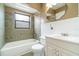 Well-lit bathroom featuring a tub with tiled walls and a large, unique mirror at 2924 S Semoran Blvd # D2, Orlando, FL 32822