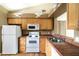Functional kitchen with white appliances, light wood cabinetry, and tile countertops at 2924 S Semoran Blvd # D2, Orlando, FL 32822