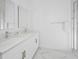 Bright bathroom with double sinks, modern fixtures, and a glass-enclosed shower with marble accents at 296 Famagusta Dr, Davenport, FL 33896