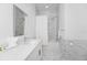 Modern bathroom with marble-style tiled shower/tub featuring a rainfall showerhead and a bright vanity with modern fixtures at 296 Famagusta Dr, Davenport, FL 33896