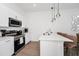 Stylish kitchen with stainless steel appliances, white countertops, and modern pendant lights at 296 Famagusta Dr, Davenport, FL 33896