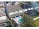 Drone view of the backyard features a pool with a lounge area and a covered patio with blue outdoor sofa at 3310 Stonewyck St, Orlando, FL 32824