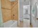 Tiled shower and bathroom featuring tan tile work and an open doorway to an additional bathroom at 3310 Stonewyck St, Orlando, FL 32824