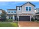Charming two-story home with stone accents, manicured landscaping, and a brick driveway at 3310 Stonewyck St, Orlando, FL 32824