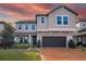 Charming two-story home with stone accents, manicured landscaping, and a brick driveway at 3310 Stonewyck St, Orlando, FL 32824