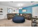 Cozy living room featuring plush sectional sofa, large round ottoman and blue accent wall at 3310 Stonewyck St, Orlando, FL 32824