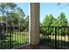 Balcony with black metal railing overlooks a green space and pond view at 413 Summit Ridge Pl # 215, Longwood, FL 32779