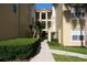 Well-maintained exterior view of the apartment buildings with green shrubbery and concrete walkway at 413 Summit Ridge Pl # 215, Longwood, FL 32779