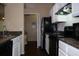 Kitchen with white cabinets, black appliances, tile backsplash, and granite countertops at 413 Summit Ridge Pl # 215, Longwood, FL 32779