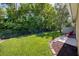 Private backyard featuring green lawn, bordering trees, and a partial view of the home's exterior at 432 Harbor Winds Ct, Winter Springs, FL 32708