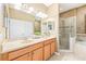 Bright bathroom featuring double sinks, vanity, and a separate shower and tub with glass doors at 432 Harbor Winds Ct, Winter Springs, FL 32708