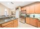 Updated kitchen with stainless steel refrigerator, granite countertops, and tile flooring at 432 Harbor Winds Ct, Winter Springs, FL 32708