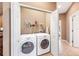 Practical laundry room with side-by-side washer and dryer units, shelving, and a hanging rack at 432 Harbor Winds Ct, Winter Springs, FL 32708