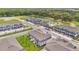 Aerial view of newly built townhomes with well-manicured lawns, a serene pond, and lush green trees in the background at 4353 Campsite Loop, Orlando, FL 32824