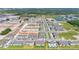 Aerial view of a community featuring completed and in-progress townhomes, green spaces, and a pond, all neatly arranged at 4353 Campsite Loop, Orlando, FL 32824