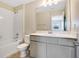 Bright bathroom featuring a shower-tub combo, white vanity, and a large mirror for added convenience at 4353 Campsite Loop, Orlando, FL 32824