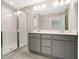Modern bathroom features dual sinks, gray cabinets, a large mirror, and a sleek glass-enclosed shower at 4353 Campsite Loop, Orlando, FL 32824