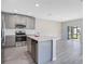 Modern kitchen features stainless steel appliances, a center island, and stylish gray cabinets at 4353 Campsite Loop, Orlando, FL 32824