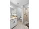 Bathroom featuring walk-in shower with updated tile, a single sink vanity, and mosaic tile flooring at 4636 Fern Pine Dr, Orlando, FL 32808