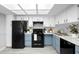 Well-lit kitchen with white upper cabinets, blue lower cabinets, black appliances, and plenty of counter space at 4636 Fern Pine Dr, Orlando, FL 32808