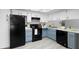 Modern kitchen features white and blue cabinets, black appliances, and a spacious layout, perfect for cooking and entertaining at 4636 Fern Pine Dr, Orlando, FL 32808