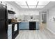 Charming kitchen with black appliances, tile floor, and blue cabinets at 4636 Fern Pine Dr, Orlando, FL 32808