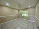 Spacious bedroom featuring tile floors and a ceiling fan for added comfort at 5050 Hidden Springs Blvd, Orlando, FL 32819